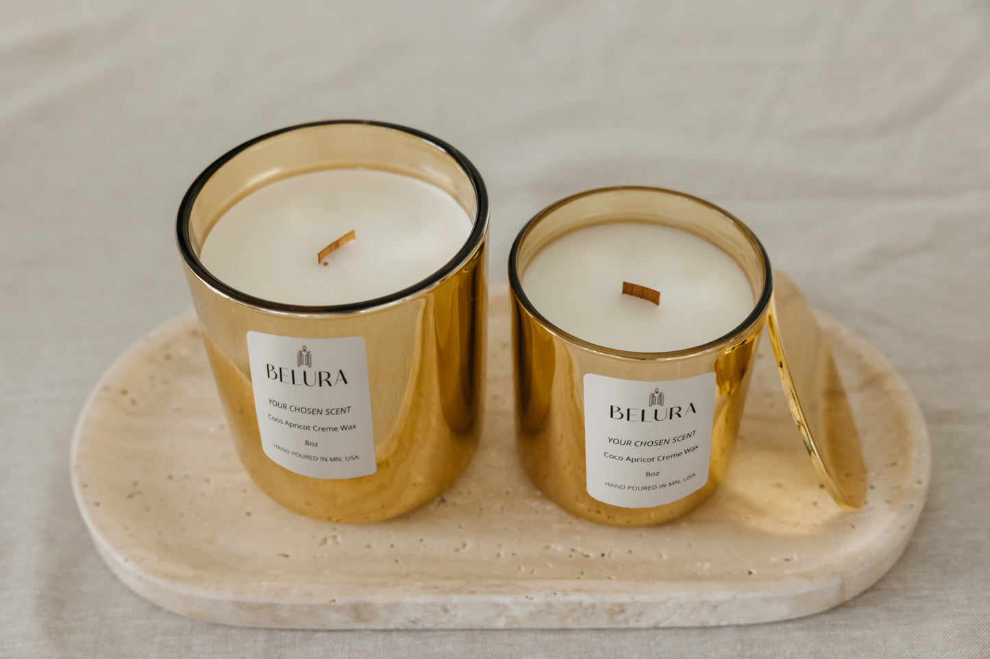 Organic candles in lustrous gold jars on tray